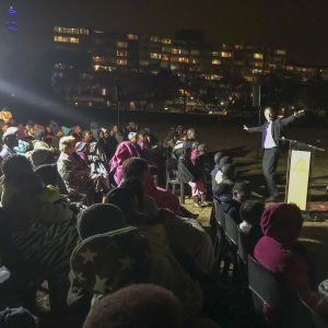 John preaching to a crowd at night