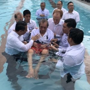 Man in wheelchair being baptized
